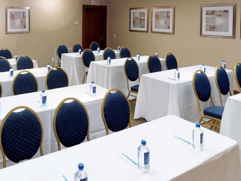 A meeting room with rows of tables and chairs, set up for an event